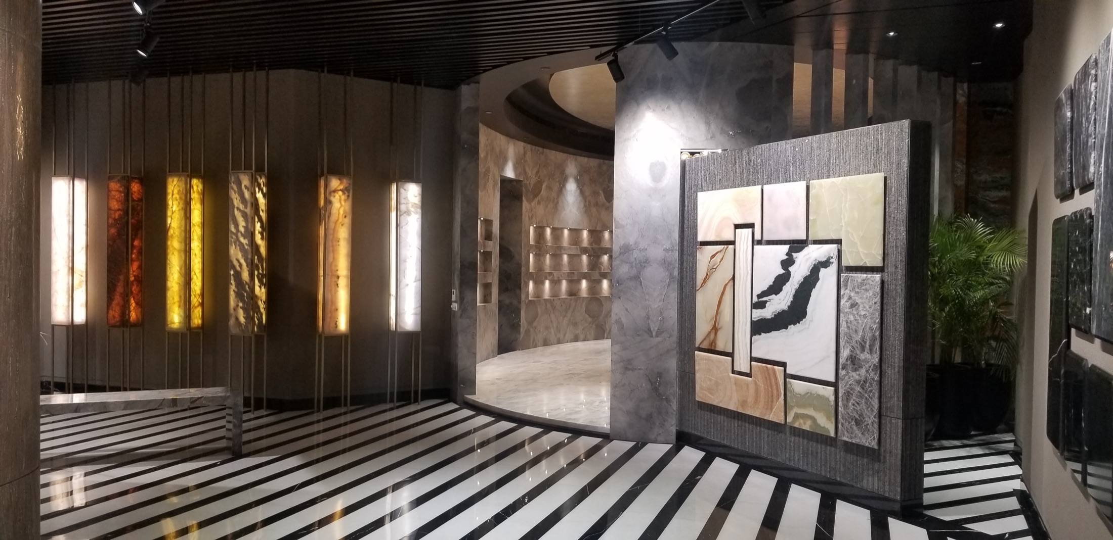 Stone gallery with backlit onyx panels and striped marble floor