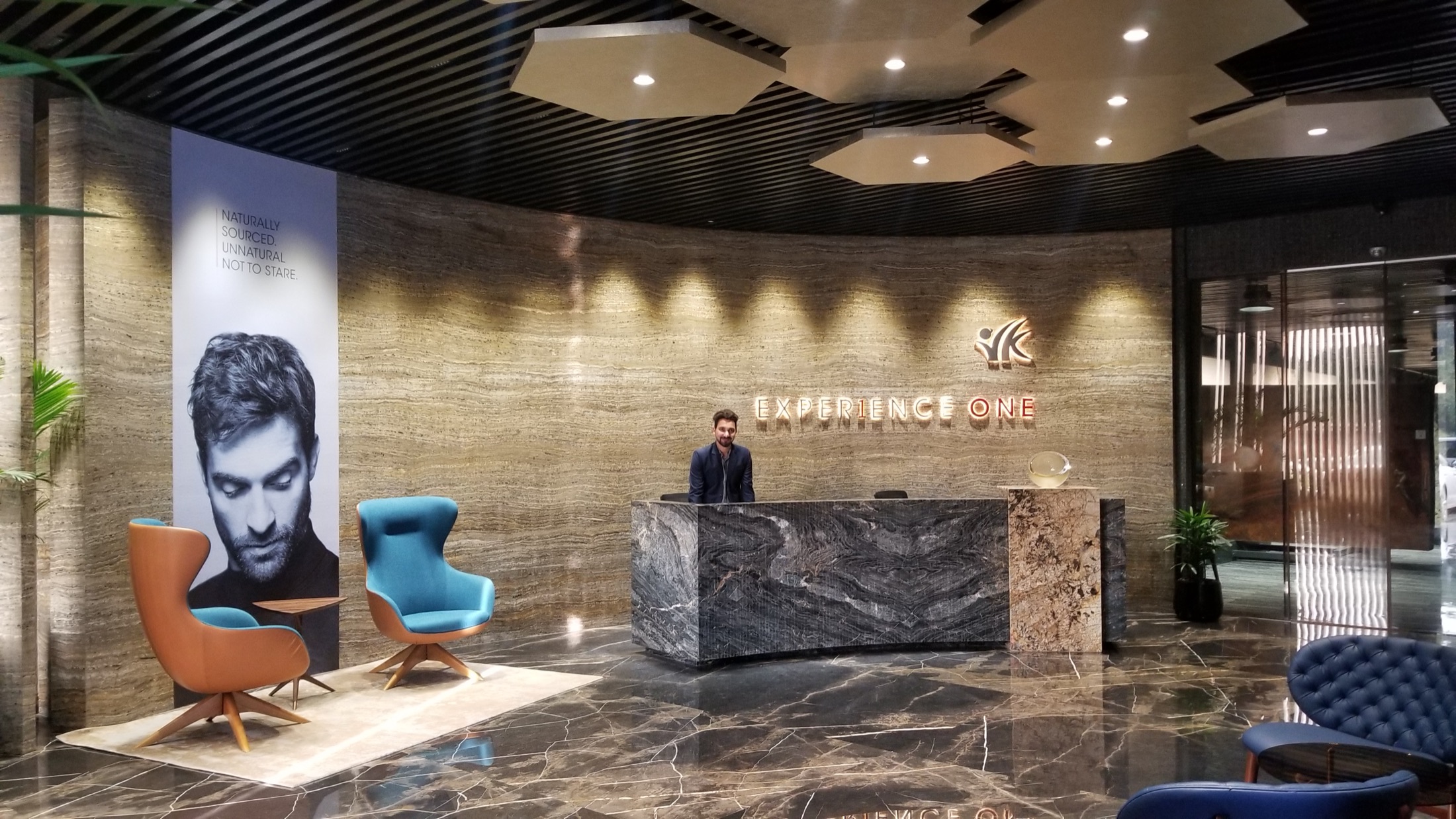 Reception desk with travertine curved wall and backlit signage