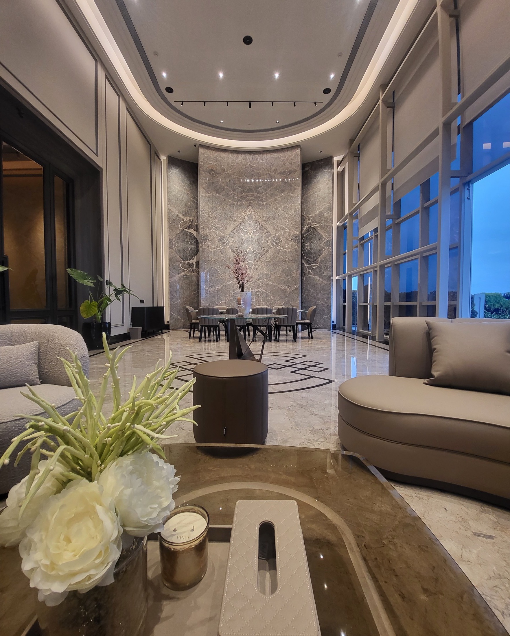 Double-height lounge with marble feature wall and skyline view