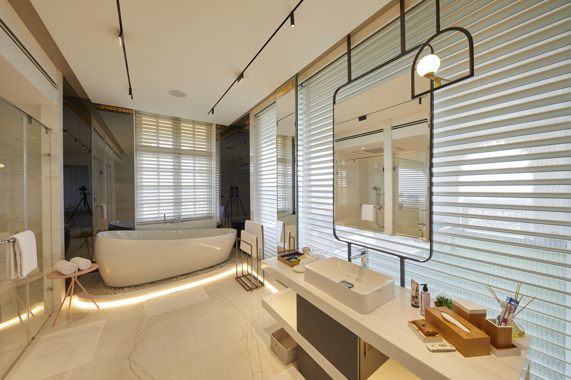 Hotel bathroom with freestanding tub and louvred glass