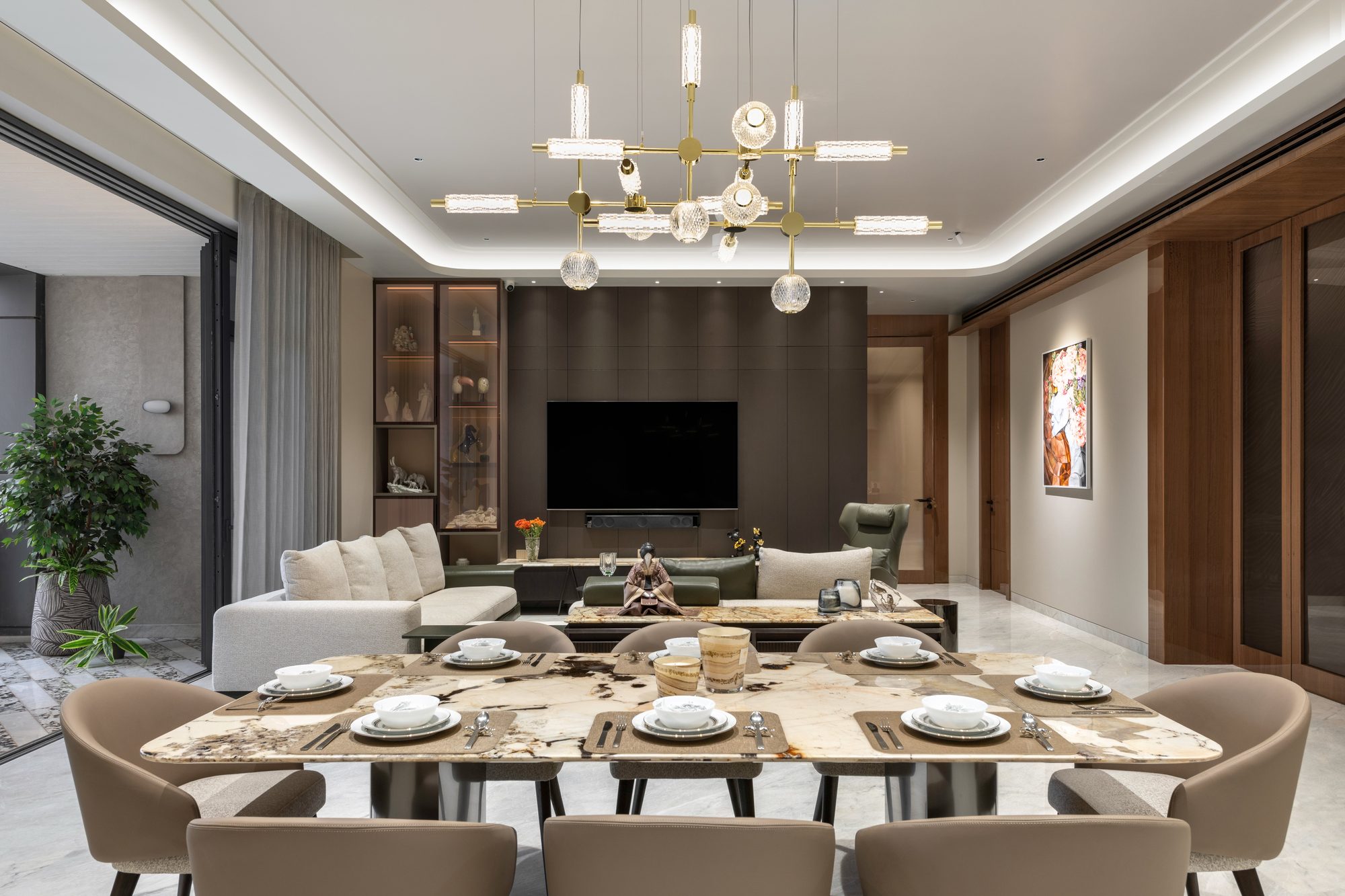Formal living and dining area with brass sculptural chandelier