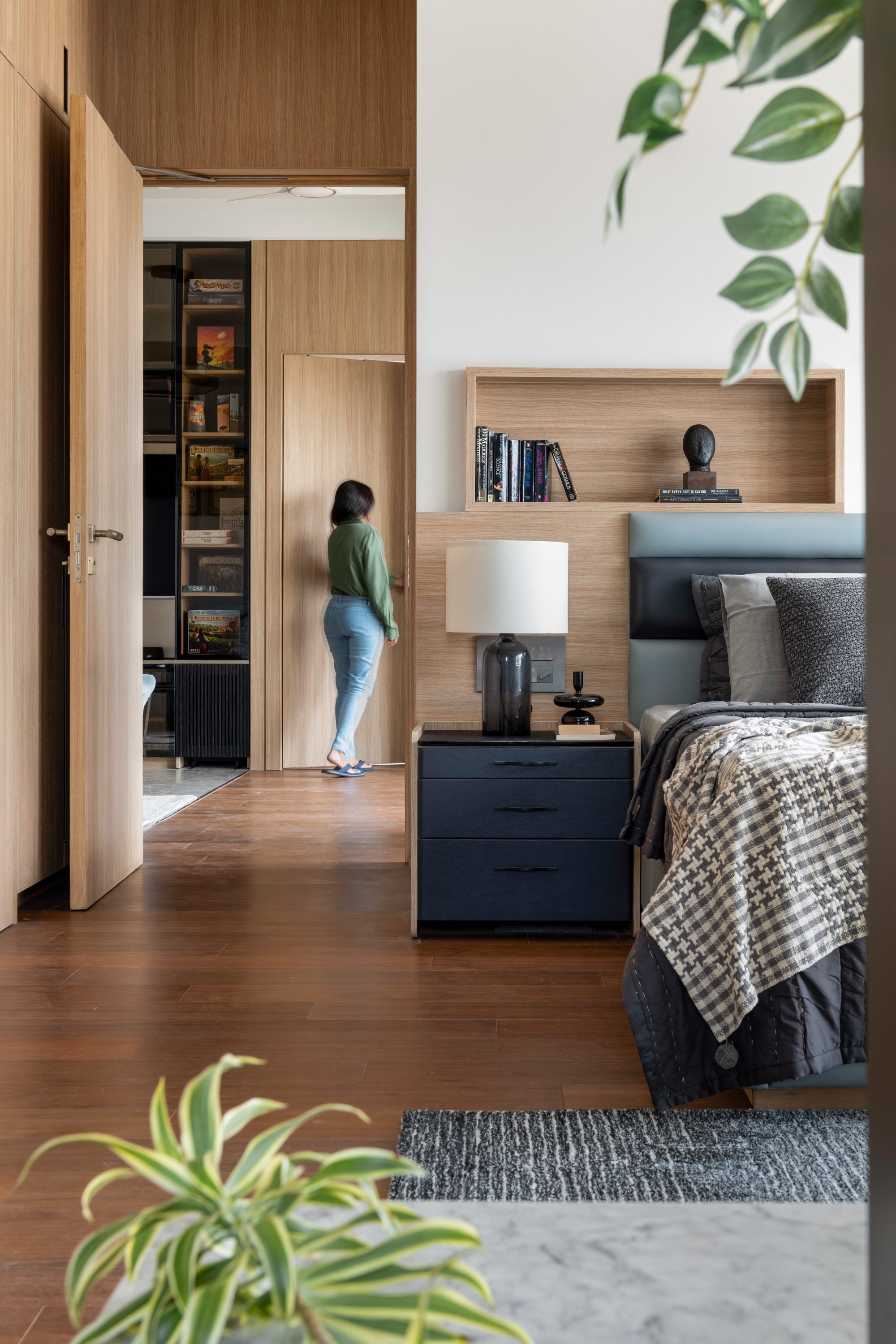 Bedroom in warm timber tones with reading nook beyond