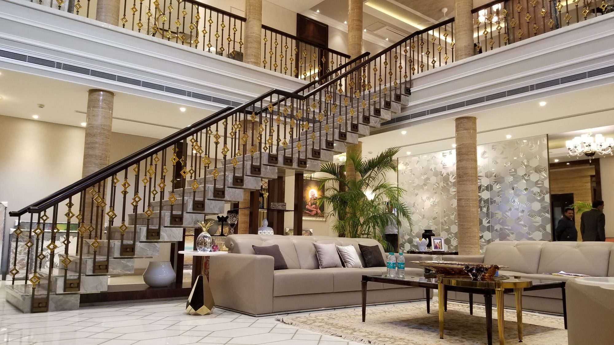 Double-height lobby with marble staircase and brass balustrade